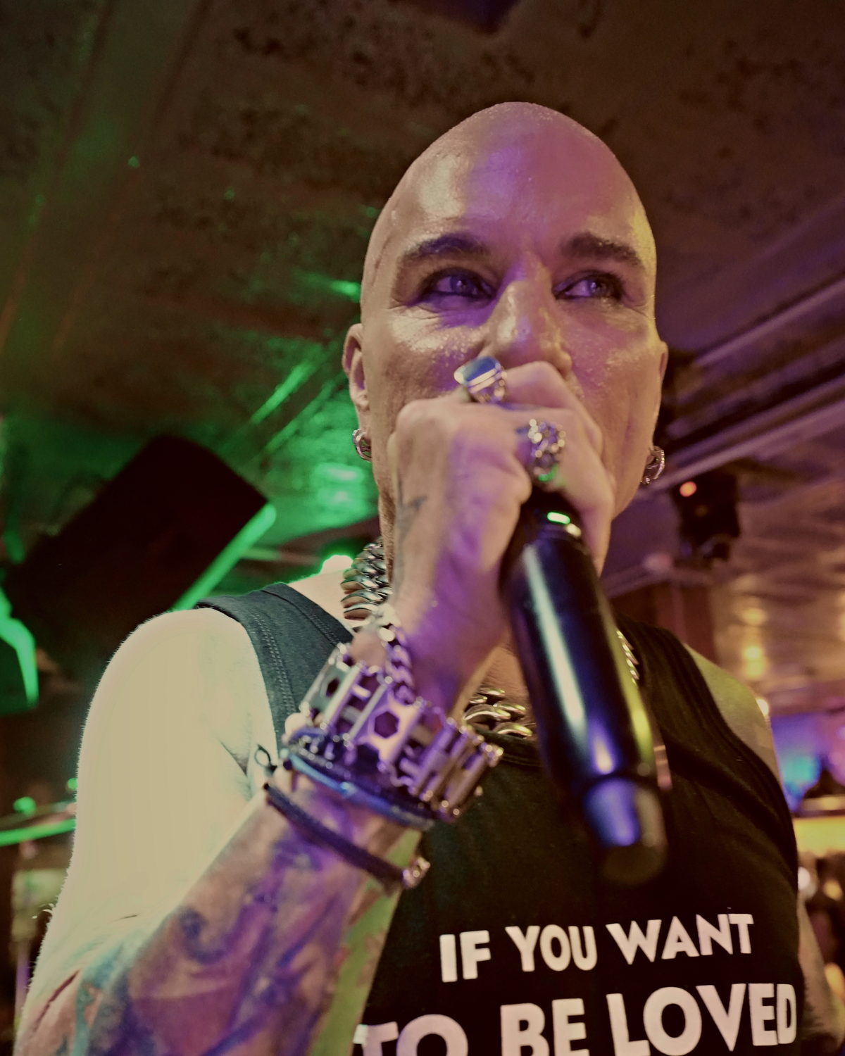 Close-up of Kelly Marlow live on stage with the "If You Want To Be Loved… Be Lovable" print